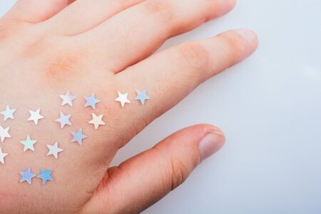 Little bright stars on a on hand on gray backgroundの写真素材