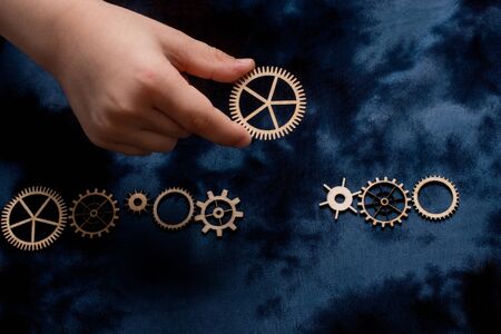 Wooden cogwheels on a fabric industry concept information.