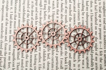 Wooden cogwheels on a page of a book. Industry concept information.の写真素材