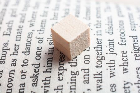 wooden toy cubes placed on a book page in Englishの写真素材