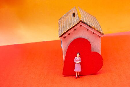 Home with love symbol and woman figurine . Happy family, real estateの写真素材