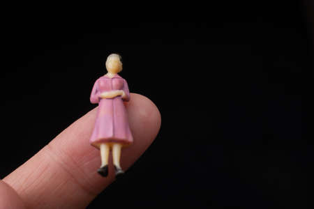 Figurine model women sitting on finger of hand