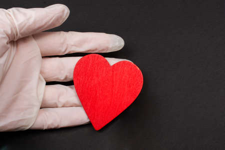 Hand in sterile glove hold a heart. Concept of health careの写真素材