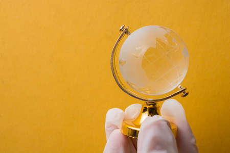 The pandemic concept. Hands in white gloves holding a globeの写真素材