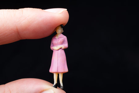 Figurine model women sitting on finger of handの写真素材