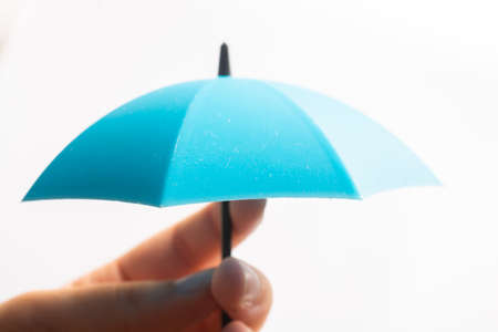 Hand with small tiny umbrella in handの写真素材
