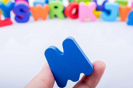 Hand holding letter cube M of made of woodの写真素材