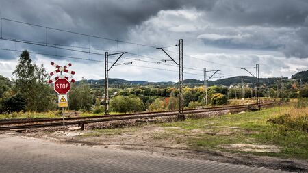 Stop sign, unguarded railroad crossing in Walbrzych, in the distance you can see the mountains.