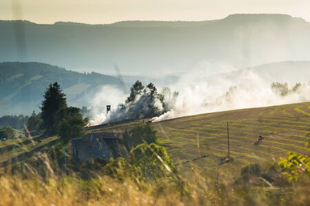 Autumn burning hay in a field, a farm in the mountainsの写真素材