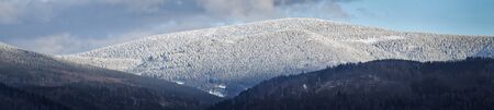 Winter in the mountains, snow-covered mountain range with white forest. Snow in the high parts of...