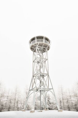 High, snow-covered lookout tower on the top of the Jagodna mountain, winter season. Lookout point on the hiking trail.の写真素材
