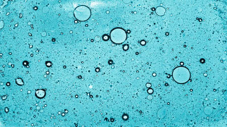 Round fat bubbles float on the water surface. Top view of circles of different sizes.