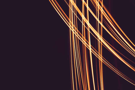 Painting with light at night, bright orange line shape on a black backgroud. The light source moves within the frame.の写真素材