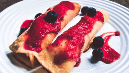 Pancakes with white cheese and strawberry mousse served on a plate. Dish sprinkled with blueberries.の写真素材