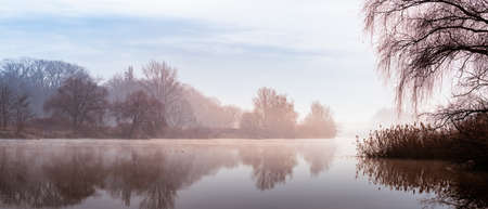 A cold morning on the Odra River in Wroclaw, a delicate fog rises above the water. River bed with...