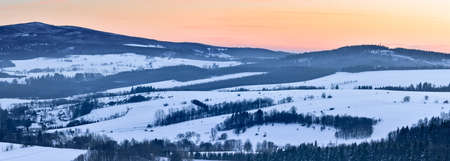 Panorama of the mountain range, view in winter from the lookout point in the Stolowe Mountains. Winter landscape with a colorful sky during the sunset.の写真素材