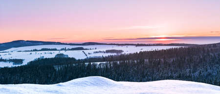 Panorama of the mountain range, view in winter from the lookout point in the Stolowe Mountains. Winter landscape with a colorful sky during the sunset.の写真素材