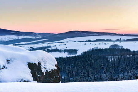 Panorama of the mountain range, view in winter from the lookout point in the Stolowe Mountains. Winter landscape with a colorful sky during the sunset.の写真素材