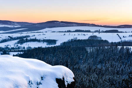 Panorama of the mountain range, view in winter from the lookout point in the Stolowe Mountains. Winter landscape with a colorful sky during the sunset.の写真素材