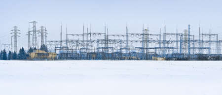 Electricity transmission lines with transformer stations. The masts are placed outside the city and transport energy in different directions, a view on a winter cloudy day.の写真素材