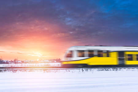 Colorful winter sunset on a cloudy evening with a train passing through Siedlec. View from the...