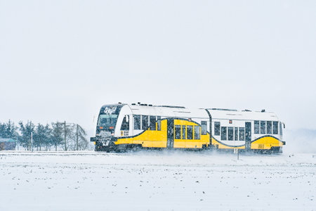 A train passing on a railroad on a winter day through a snowy landscape.のeditorial素材