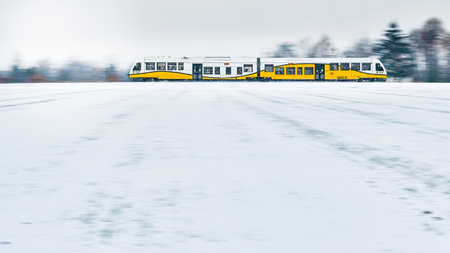 A train passing on a railroad on a winter day through a snowy landscape.