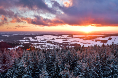 A colorful sunset in the Polish mountains of the Sudetes, the view from the top of the mountain from the Czerniec observation tower, winter evening.の写真素材