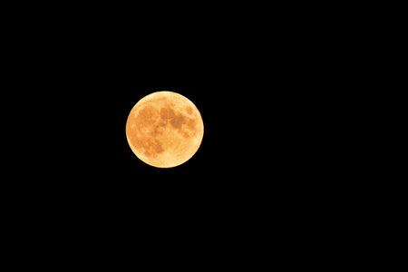 Full moon of hunters, a natural orange-colored satellite visible in the dark sky.の写真素材