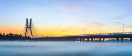 Wroclaw Redzinski bridge over the Odra river in the late evening after sunset. Thick fog over the river on a cool evening, highway.の写真素材