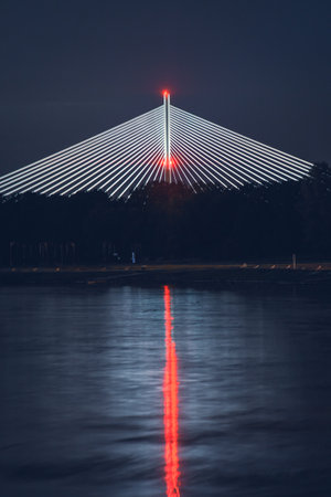 Wroclaw, Redzinski Bridge illuminated at night, the structure rises high above the trees on the banks of the Odra River.の写真素材