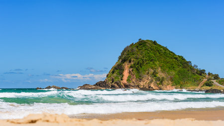 Australian coast, big rock on the seashore with blue water with waves and sandy beach, view from the beach to the seaside landscape on a summer sunny day.の写真素材