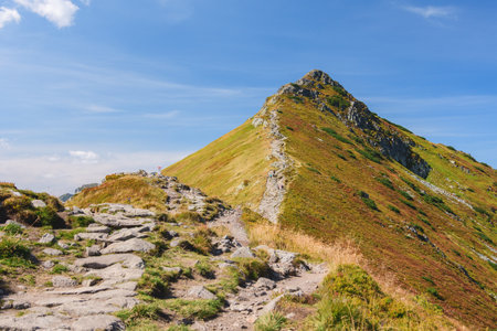 Polish Tatra Mountains, high mountain hiking trail leading to mountain peaks, mountain landscape with valleys and slopes, view on a sunny summer day.の写真素材