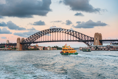 Sydney, Australia - March 04, 2023: Sydney Harbor Bridge, ferry sails on the river towards the...