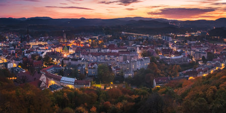 Walbrzych, sunset with a view of the city center and the Walbrzych Mountains. View of the illuminated city buildings from the observation tower in Jan Sobieski Park, colorful autumn evening.の写真素材