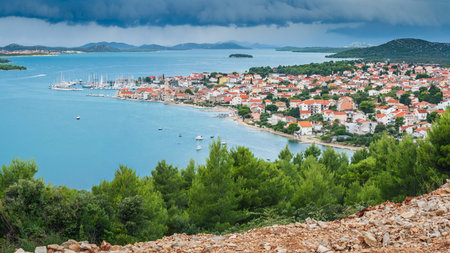 The coastal town of Pirovac in Croatia, with a panoramic view of the town, bay, and surrounding islands from Makirina Peak. Rain clouds and heavy rain pass over the islands.の写真素材