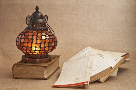 nterior Oriental brass lamp with a colorful bit of glass and old books about itの写真素材