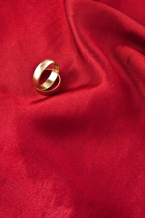 Two wedding rings on red satin backgroundの写真素材