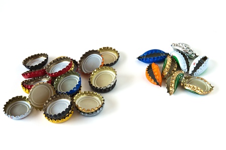 Two piles of crushed and used colored bottle tops