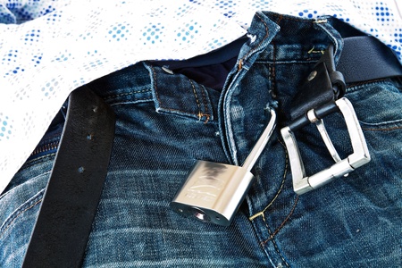 Steel Padlock locked submitting jeans under Men's shirtの写真素材