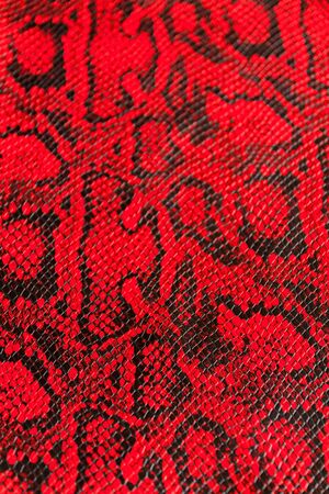 Texture of synthetic red snake skin for various purposes.Selective focus with shallow depth of...