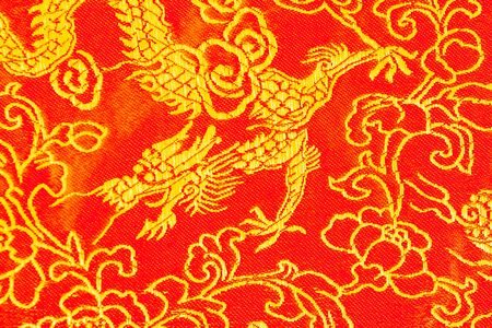 Silk fabric in yellow and red with traditional Chinese motifs.