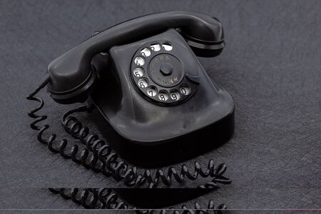 Vintage analog bakelite phone in black color. Selective focus with shallow depth of field.の写真素材