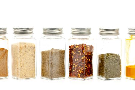 Square glass jars for storing dry kitchen spices. Selective focus with shallow depth of field.