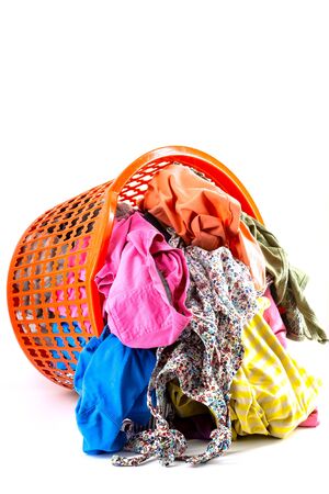 Red plastic laundry basket full of colorful clothesの写真素材