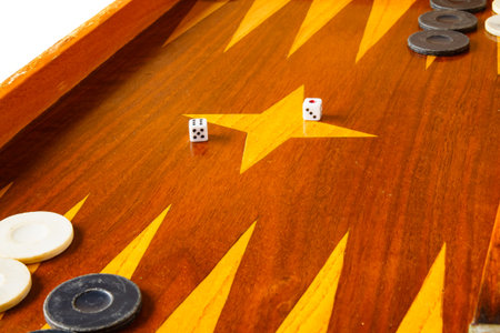 Old varnished wooden board game with plastic checkers and dice. Selective focus with shallow depth...