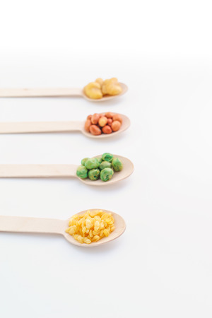 Various Nuts on the wooden spoon on White Background, Flat layの写真素材