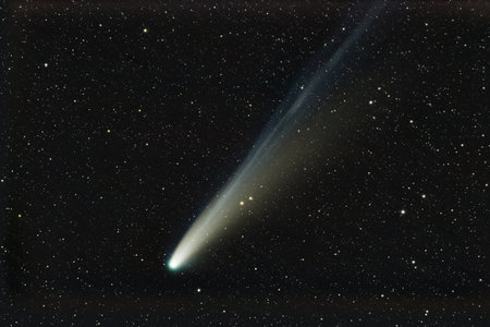 Beautiful comet with long glowing gas tail in outer space.