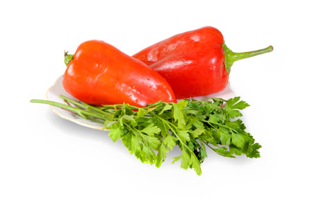 Red peppers and parsley on a plate isolated on a white backgroundの写真素材