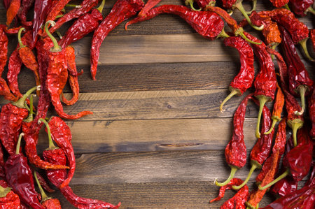 Frame of red dried hot chili peppers on wooden background with copy spaceの写真素材